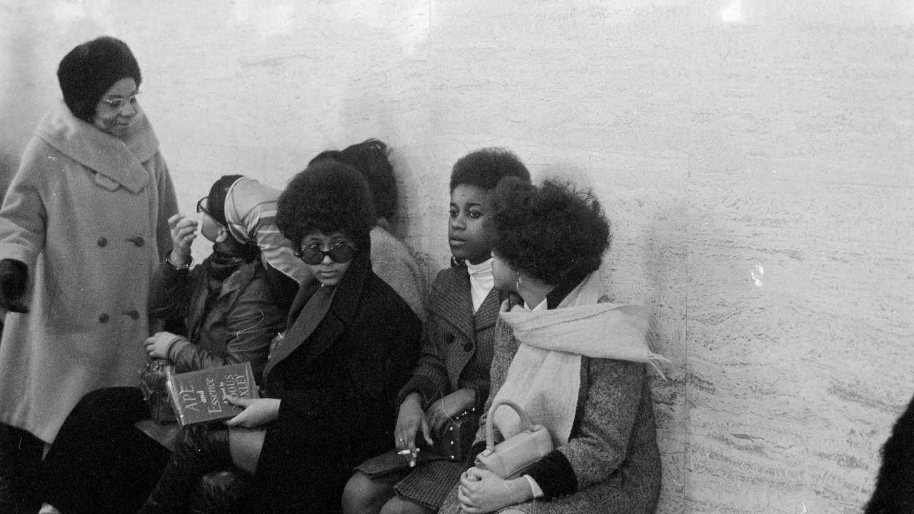 a group of women sitting together on a bench